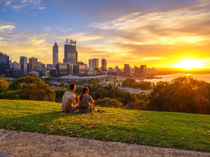 Couple watching the sunrise at Kings Park and Botanic Garden with the Perth Skyline in the background.
