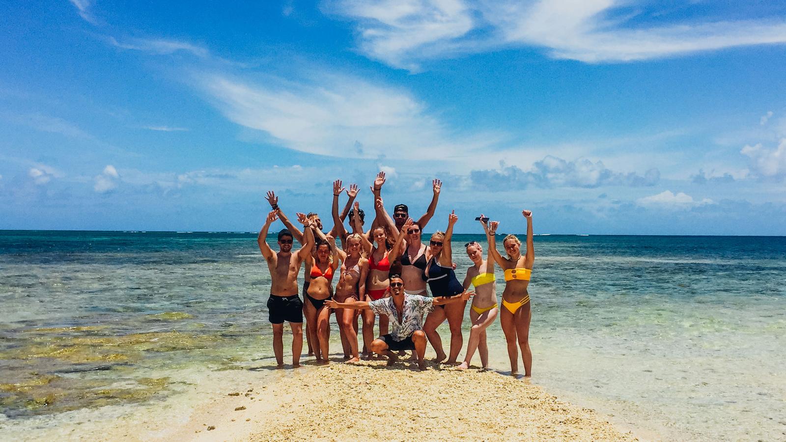 Young travellers on Siargao Island posing on the beach with surfboards, Philippines