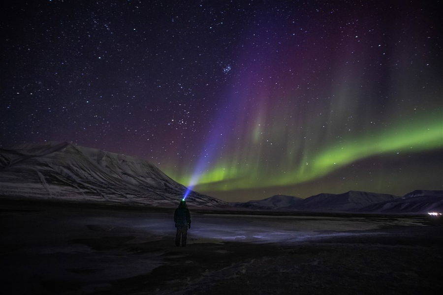 A man looking at the northern lights in norway