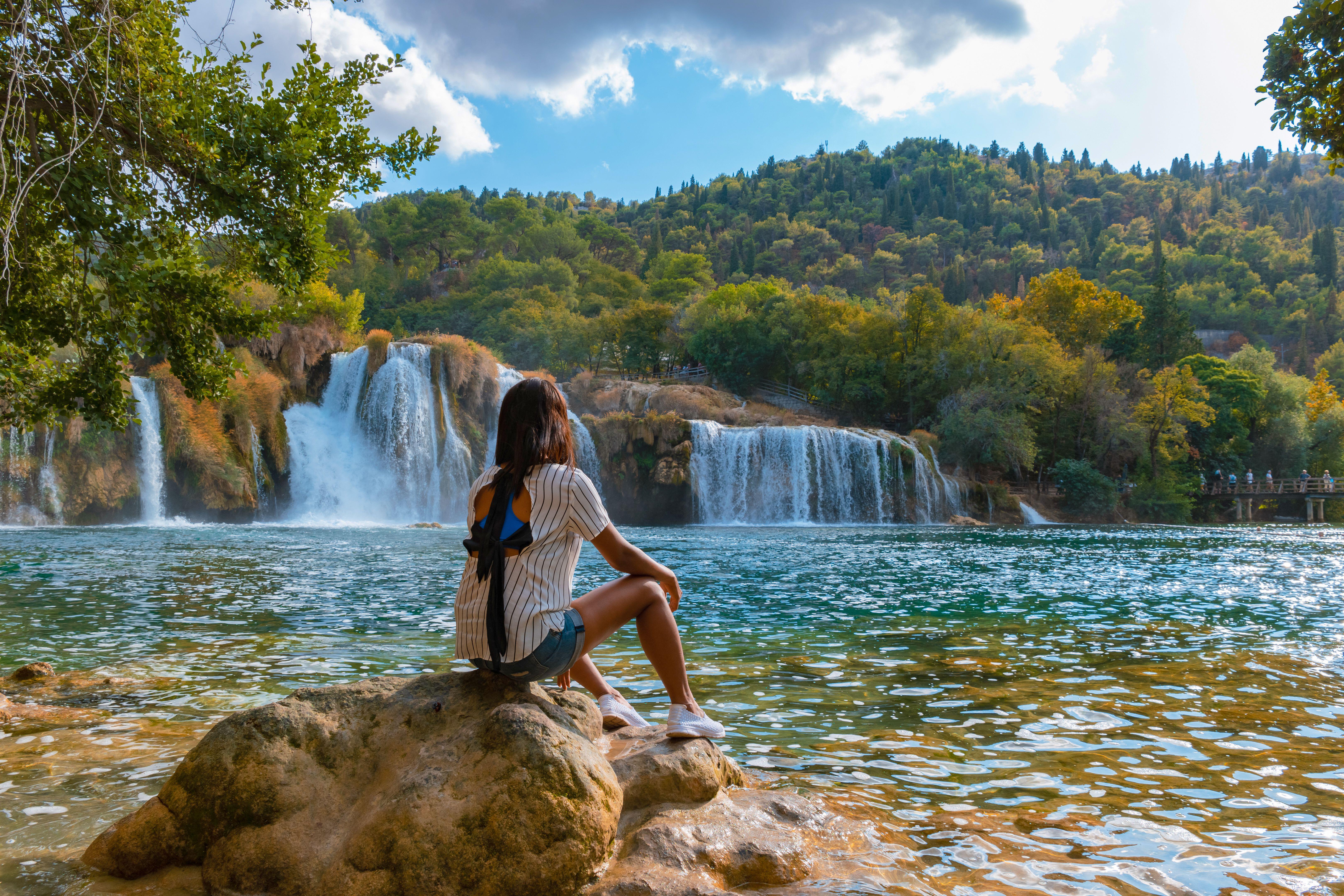 Young woman watching Krka waterfalls in National Park, Croatia