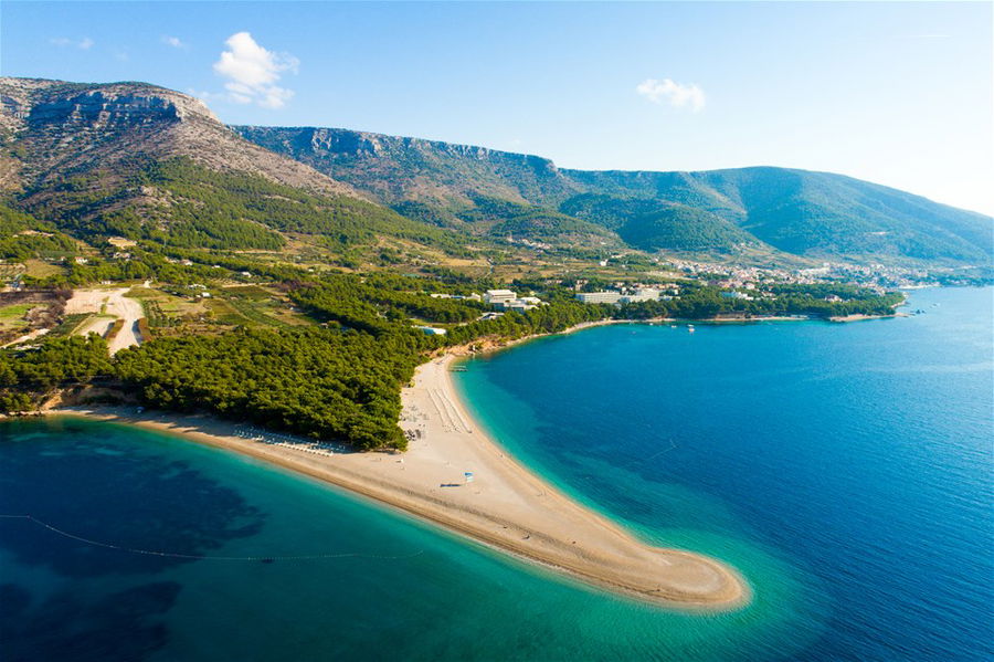 A beach peninsula juts out into bright blue waters in Croatia