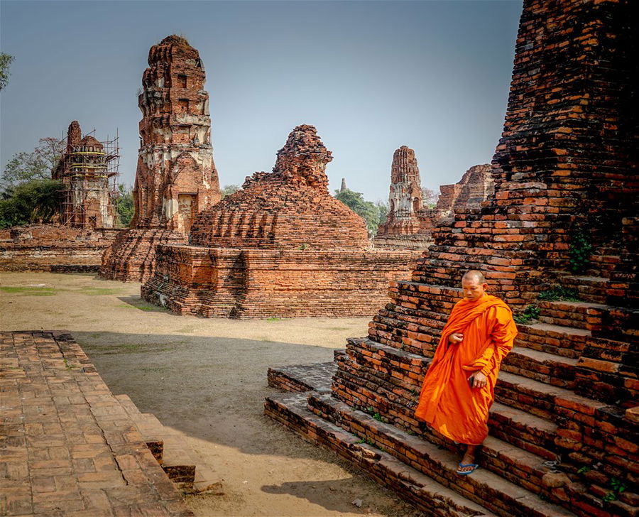 A monk in orange robes at Ayutthaya, Thailand