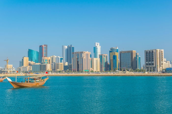 Skyline of Manama with a dhow boat