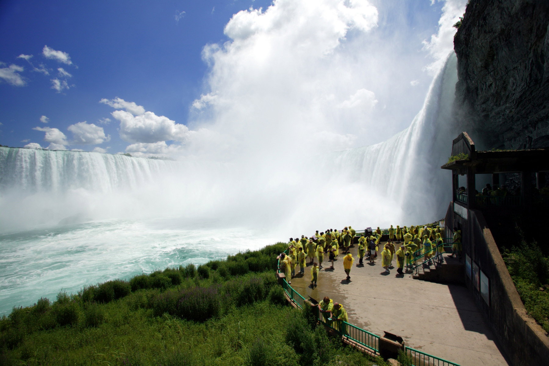 A tour group admire the thundering waters of Niagara Falls in Canada from a viewing platform, Niagara Falls Pass, Canada