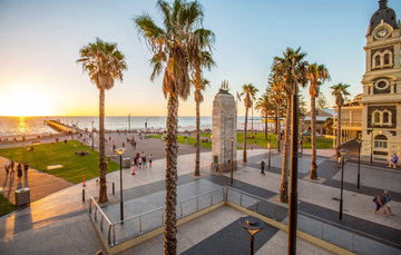 The square and pier in Adelaide leading out to the sea, with towering palm trees and pretty buildings at the forefront, South Australia