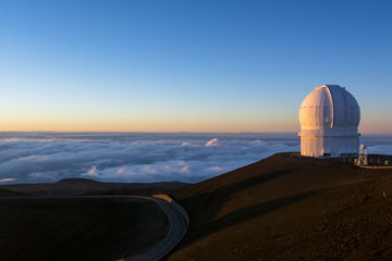 Mauna Kea star gazing observatory on top of a mountain above the clouds at dusk, Big Island Hawaii, USA