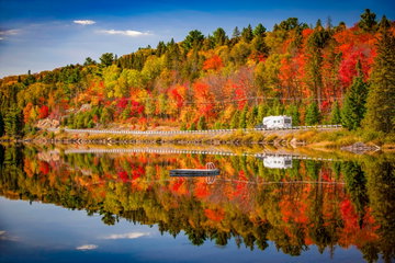 Fall forest with colorful autumn leaves and highway 60 reflecting in Lake of Two Rivers. Algonquin Park, Ontario, Canada. Autumn Motor Home Camping Canada Driving Ontario - Canada Road Algonquin Provincial Park Scenics - Nature Vehicle Trailer Travel Public Park Tree Lake Leaf Landscape - Scenery Season Vacations Adventure Highway Forest Colors Red Lush Foliage Horizontal Nature Outdoors Gold Colored Journey Land Vehicle Leisure Activity Multi Colored Orange Color Photography Reflection Water Woodland Yellow Signature 