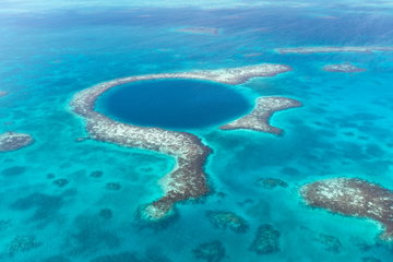 Aerial view of azure sea, coral reef and the dark blue cave of famous diving spot the Blue Hole, Belize, Caribbean Ocean, Central America