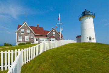Bright blue sky sits above the historic Nobska Lighthouse and its well-maintained gardens in Falmouth, Cape Cod, USA