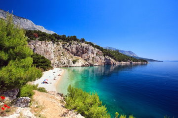 Secluded pebble beach in Croatia with limestone cliffs leading into the Adriatic Sea