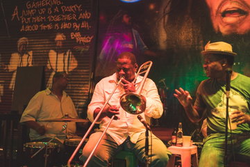 Jazz band plays in a club illuminated by stage lights, with murals on the walls, New Orleans, Louisiana, USA