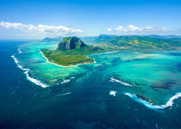 Aerial view over Mauritius Island and Le Morne Brabant Mountain showing the vast ocean and turquoise blue lagoon, Mauritius. 