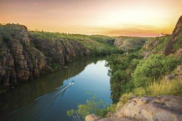 A bush-top gorge with the reflecting water below and the orange sunset behind, Northern Territory, Australia