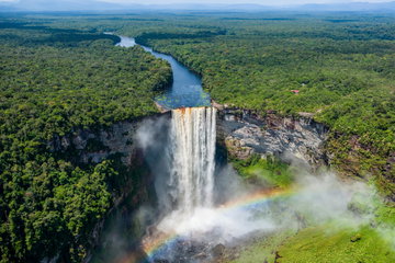 Aerial view of a waterfall cascading from a river and surrounding rainforest into mist below, Kaieteur National Park, Guyana, South America