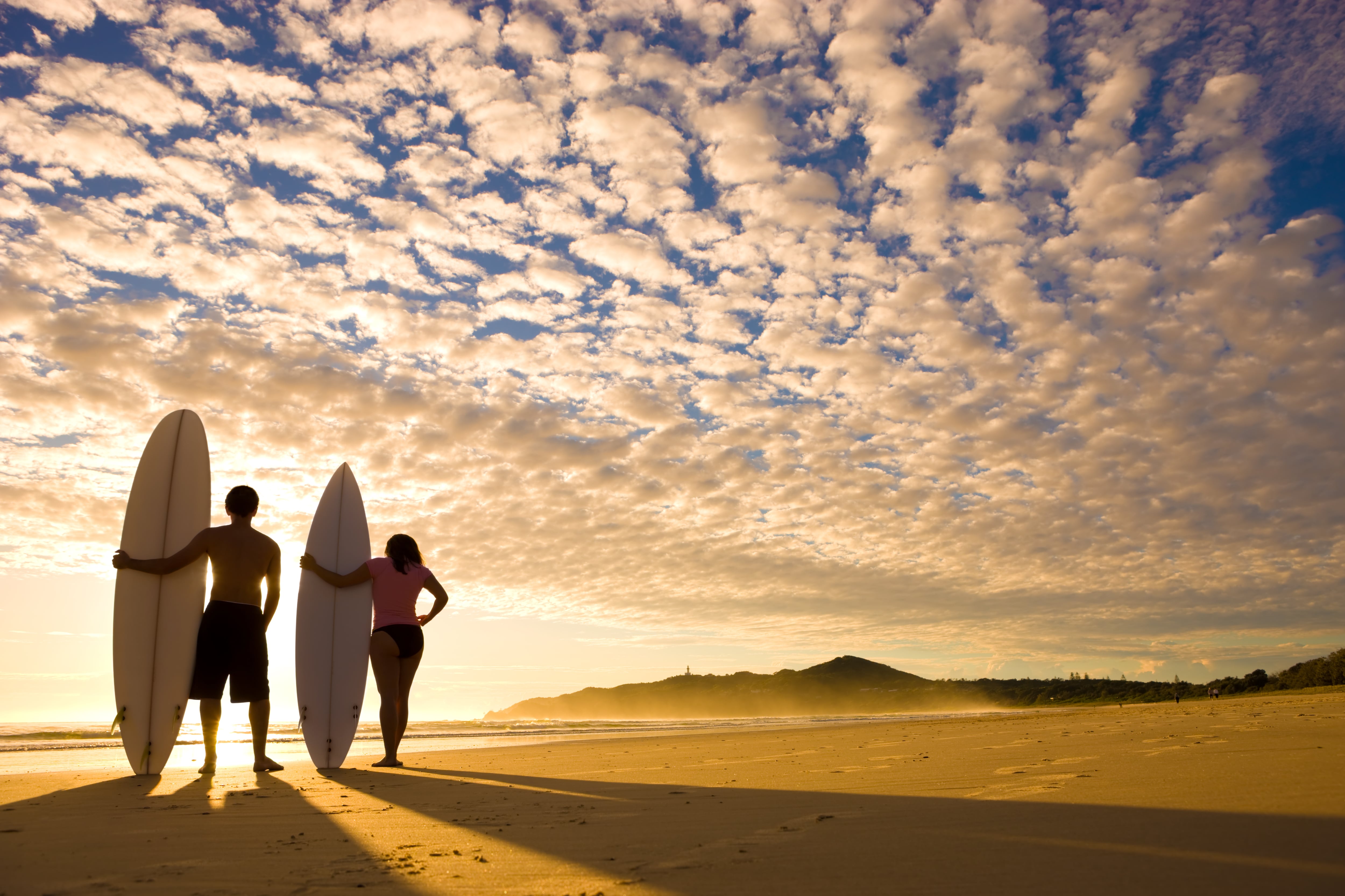 Two surfers at sunrise about to go out at Byron Bay