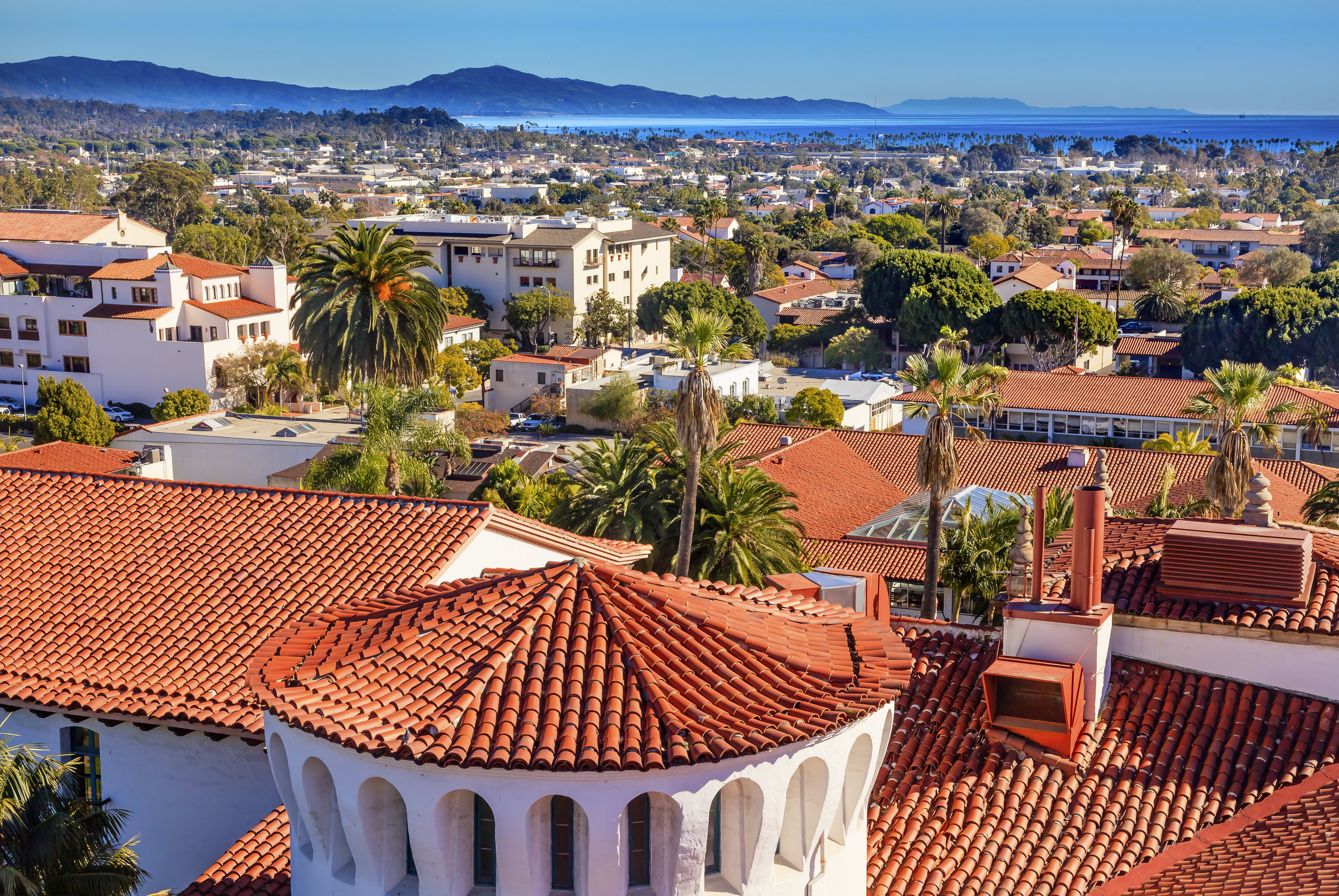 Beautiful blue sky shining down on the aqua-blue sea and lush forestry that sits next to the Bixby Bridge on Highway 1 on the Big Sur, California, USA