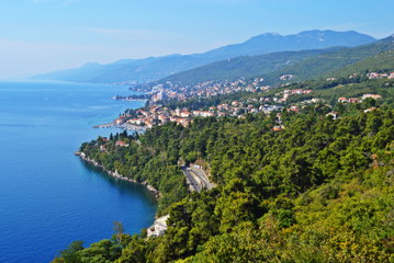 Heavily forested coast stretches into the distance on a sunny day, Opatija, Croatia