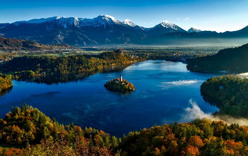 Hill top view of remarkable Lake Bled, the bluest of water surround the charming castle, with unrivalled forest views, Slovenia