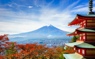 A traditional red pagoda sits in the foreground with Mt Fuji in the background. Japan, Asia