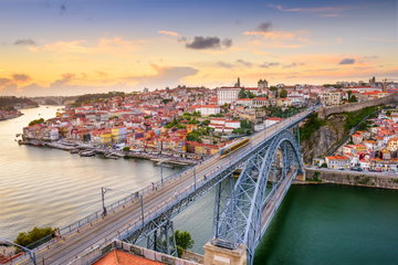 The Dom Luis Bridge over the Douro River and the multi-coloured buildings of Porto, Portugal.