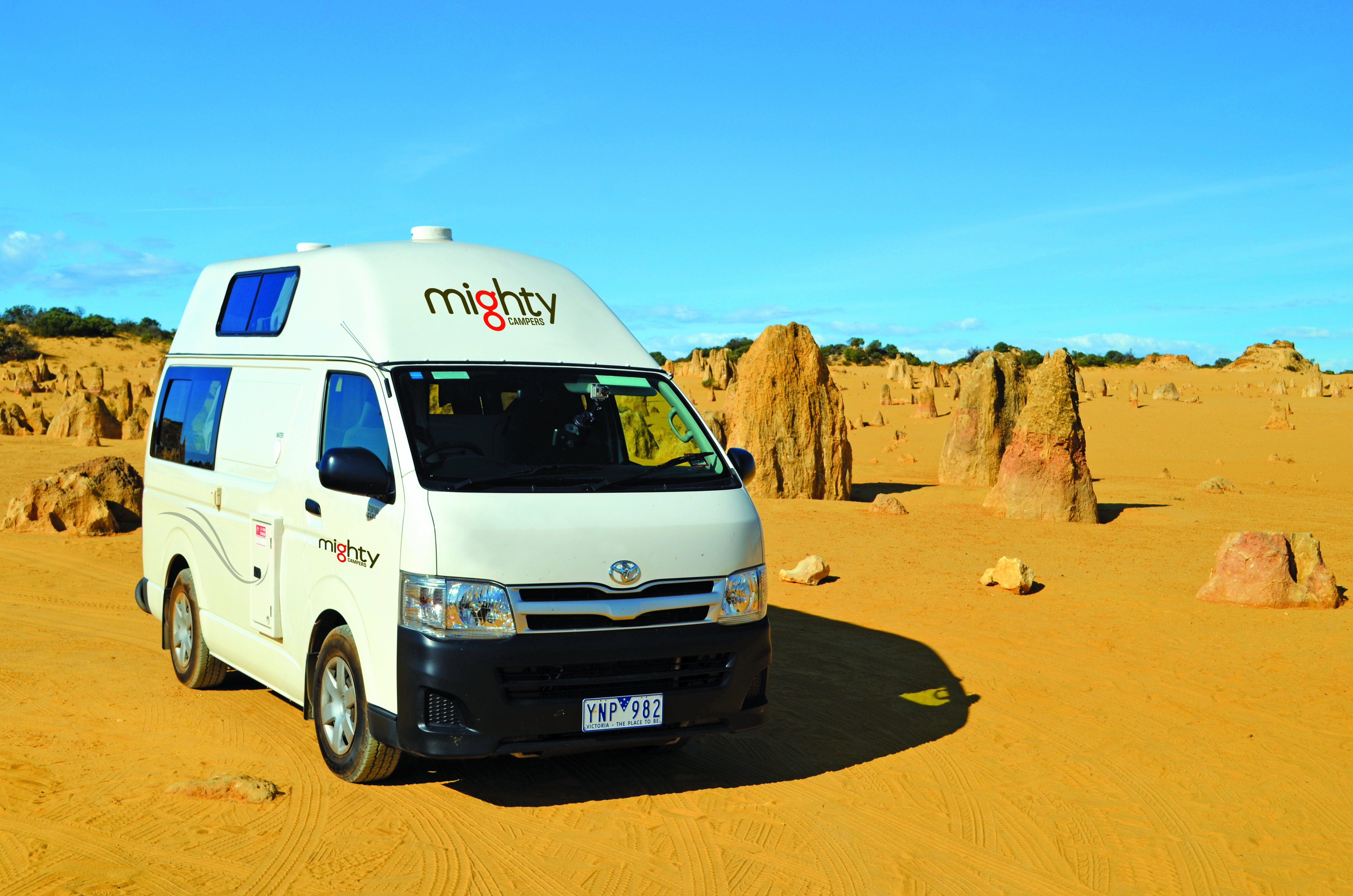 A Mighty Highball Campervan parked on the orange sand in The Pinnacles Desert, Western Australia