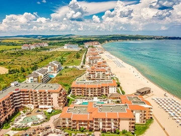 Large resort hotels lining a sandy beach and the ocean in Bulgaria