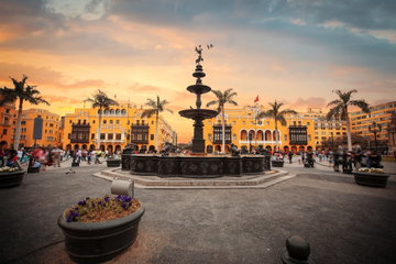 Lima’s main square, Plaza de Armas with multi-layered fountain surrounded by palm trees and orange historical buildings