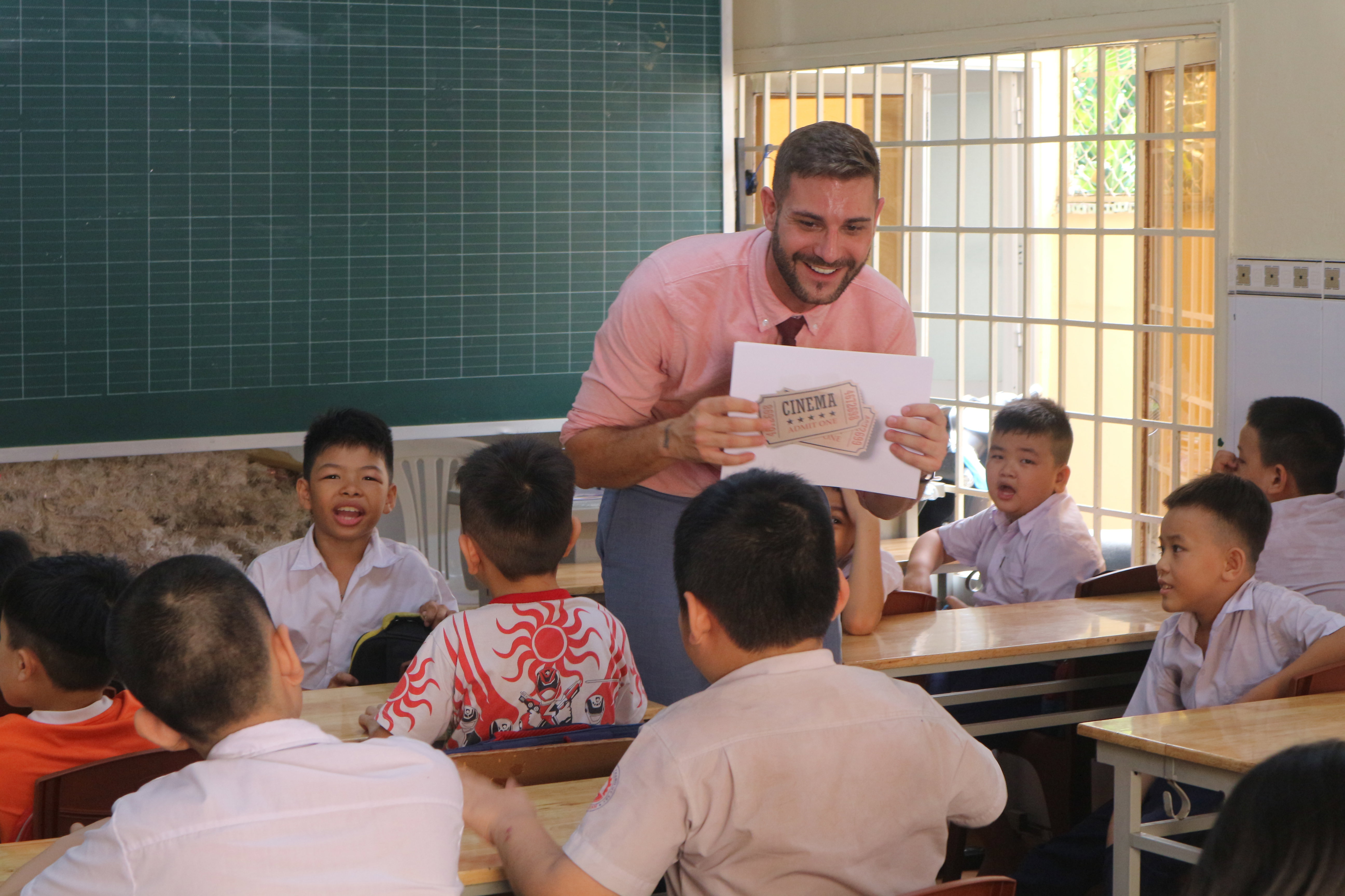 A man teaching in a classroom in Asia