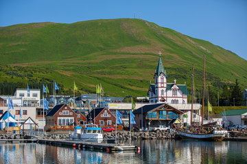 Husavik harbour in Northern Iceland with the church spire and mountain backdrop