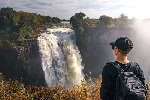 Tourist looks at the Victoria Falls on Zambezi River, Zimbabwe