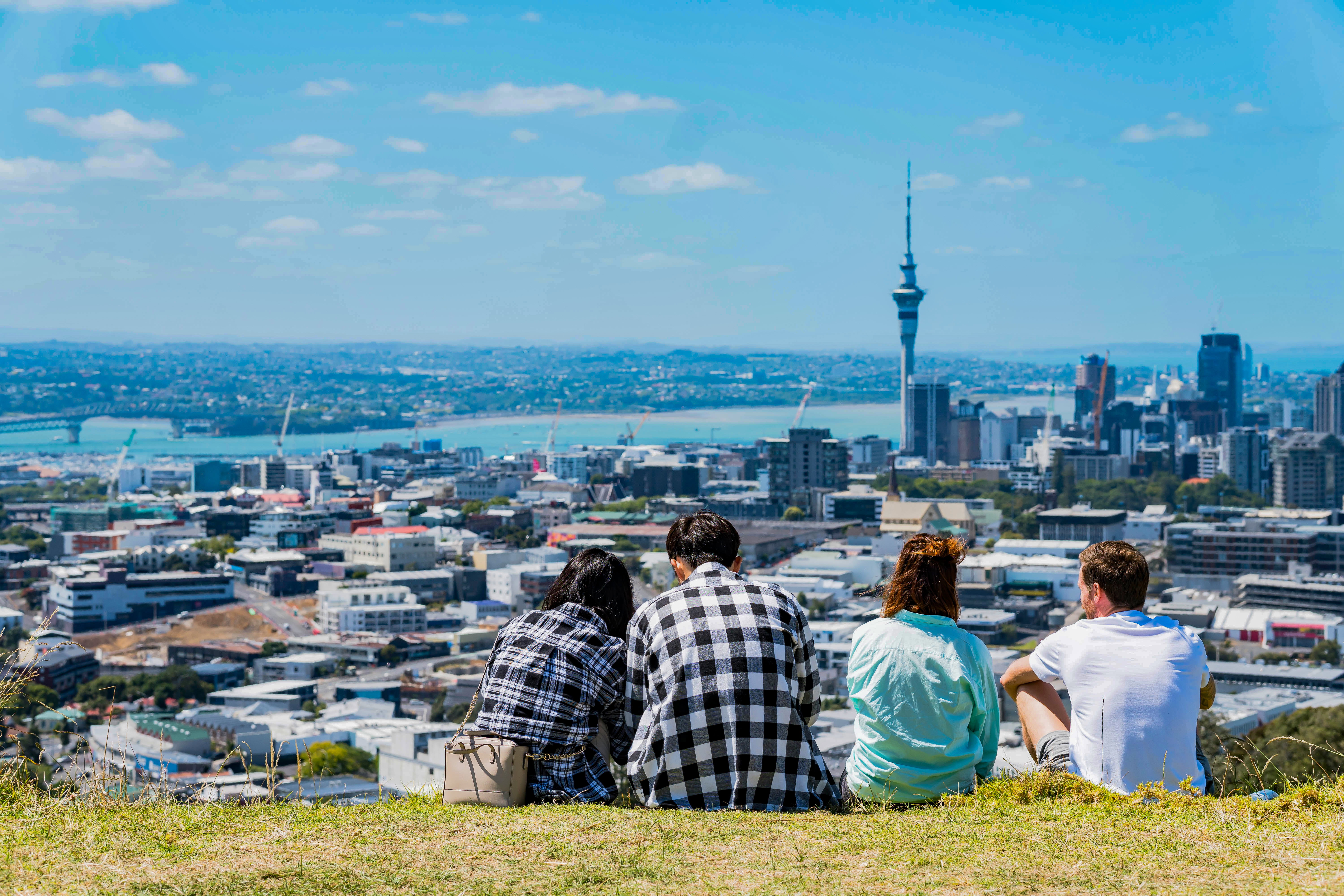 A group of friends hanging out and enjoying the view of Auckland city on Mount Eden