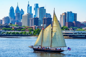Philadelphia skyline on a bright sunny day with a sail boat passing by, USA