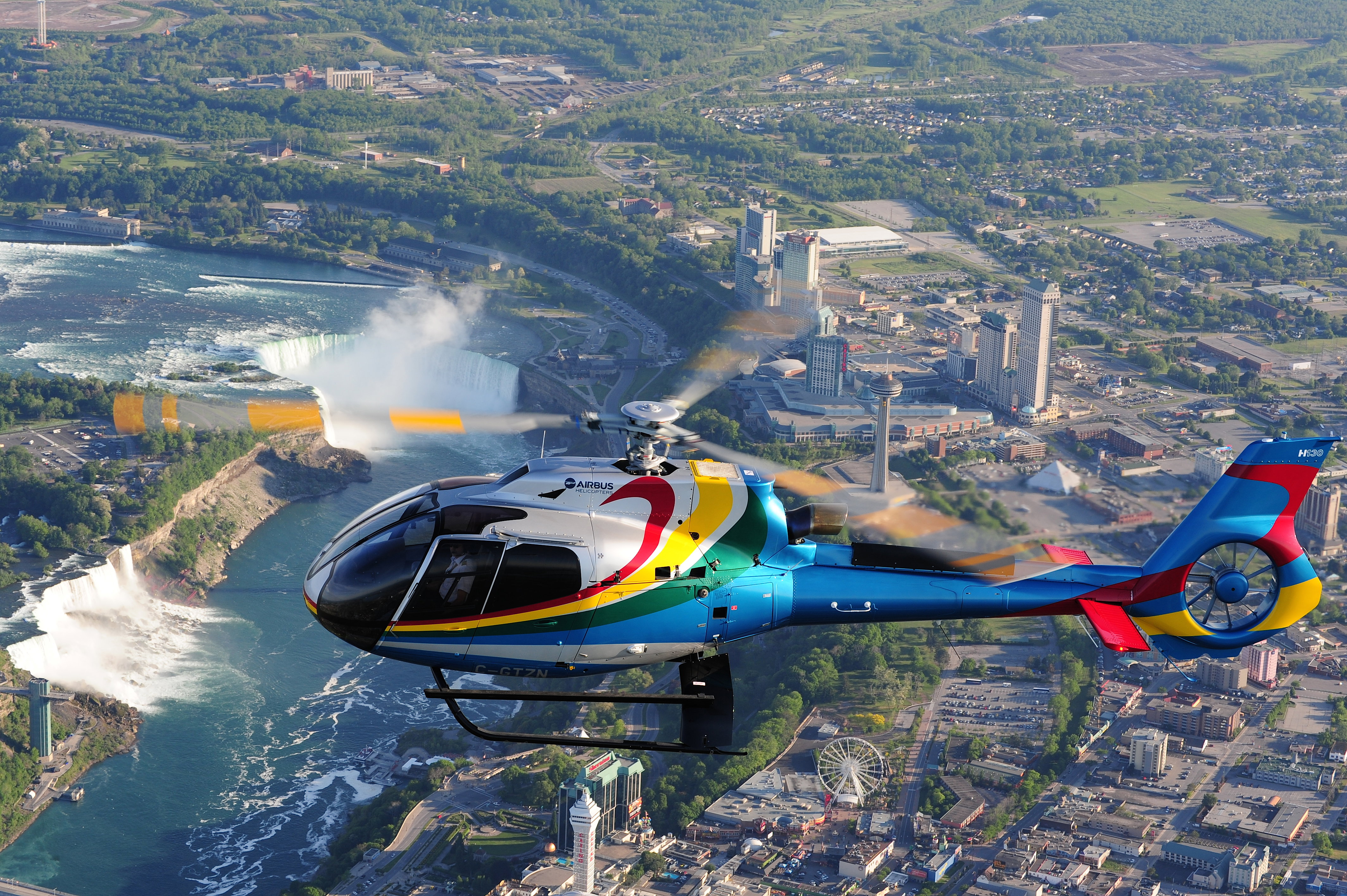 Helicopter soaring over the thundering waterfalls, on Niagara Falls Helicopter Flight, Ontario, Canada