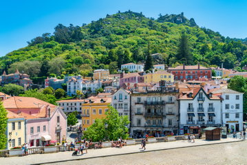 Pastel coloured buildings dotted on a hill in Sintra, Portugal