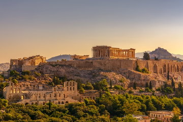 Marble and stone ruins of the Acropolis, Athens at sunrise with Lycabettus hill in the background