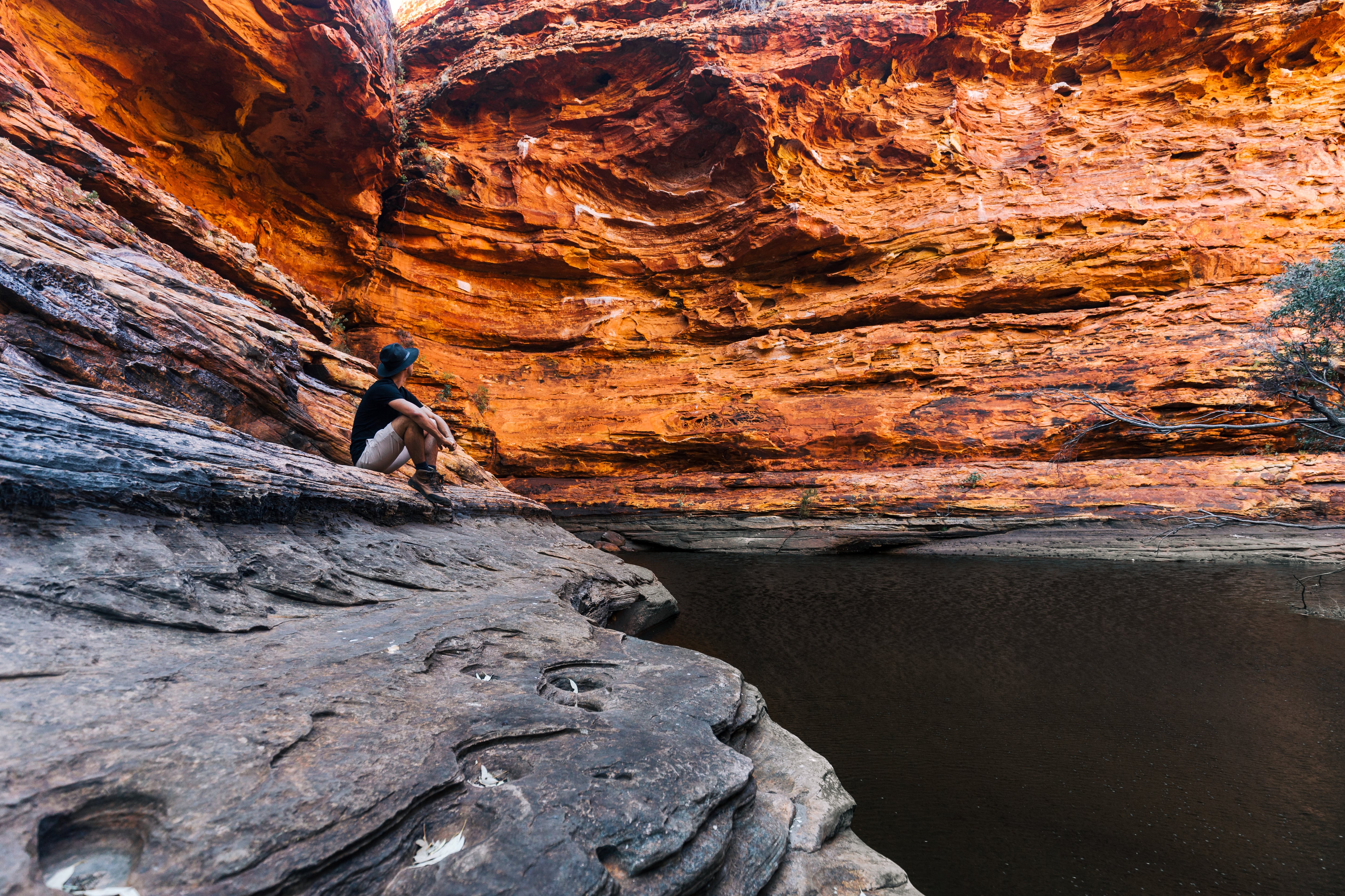 A traveller sat marvelling at the rock formation in the Red Centre, Australia
