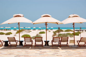 Sunbeds and umbrellas at the Beach of luxury hotel, Abu Dhabi