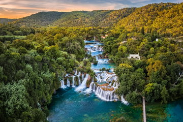 Wooden walkways wind through the tree lined waterfalls and blue waters of Plitvice Lakes National Park, Croatia