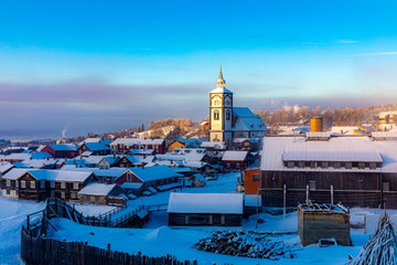 Roros church surrounded by old wooden buildings on a sunny winter’s day in Roros, Trondelag, Norway