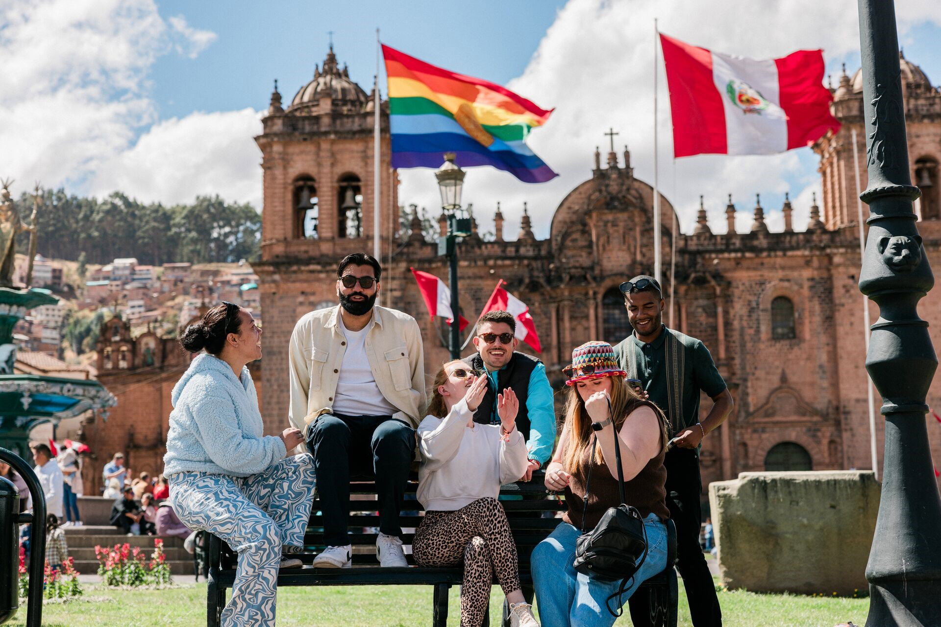 A group of travellers sat on the bench talking in Cusco, Peru