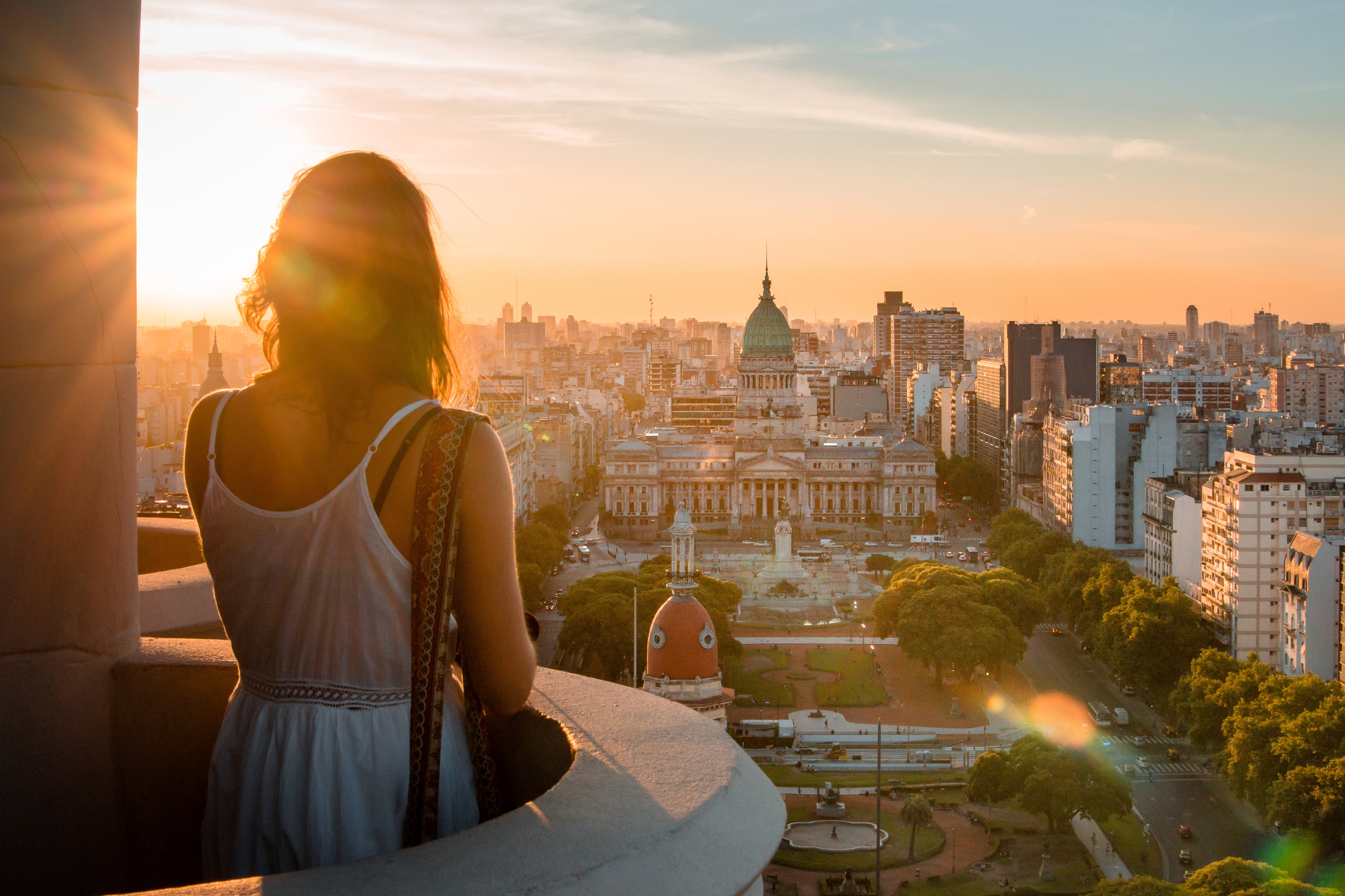 Rear View Of Woman Standing At Balcony Against Cityscape During Sunset, Buenos Aires, Argentina