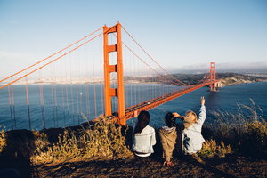 Three people looking at the Golden Gate Bridge