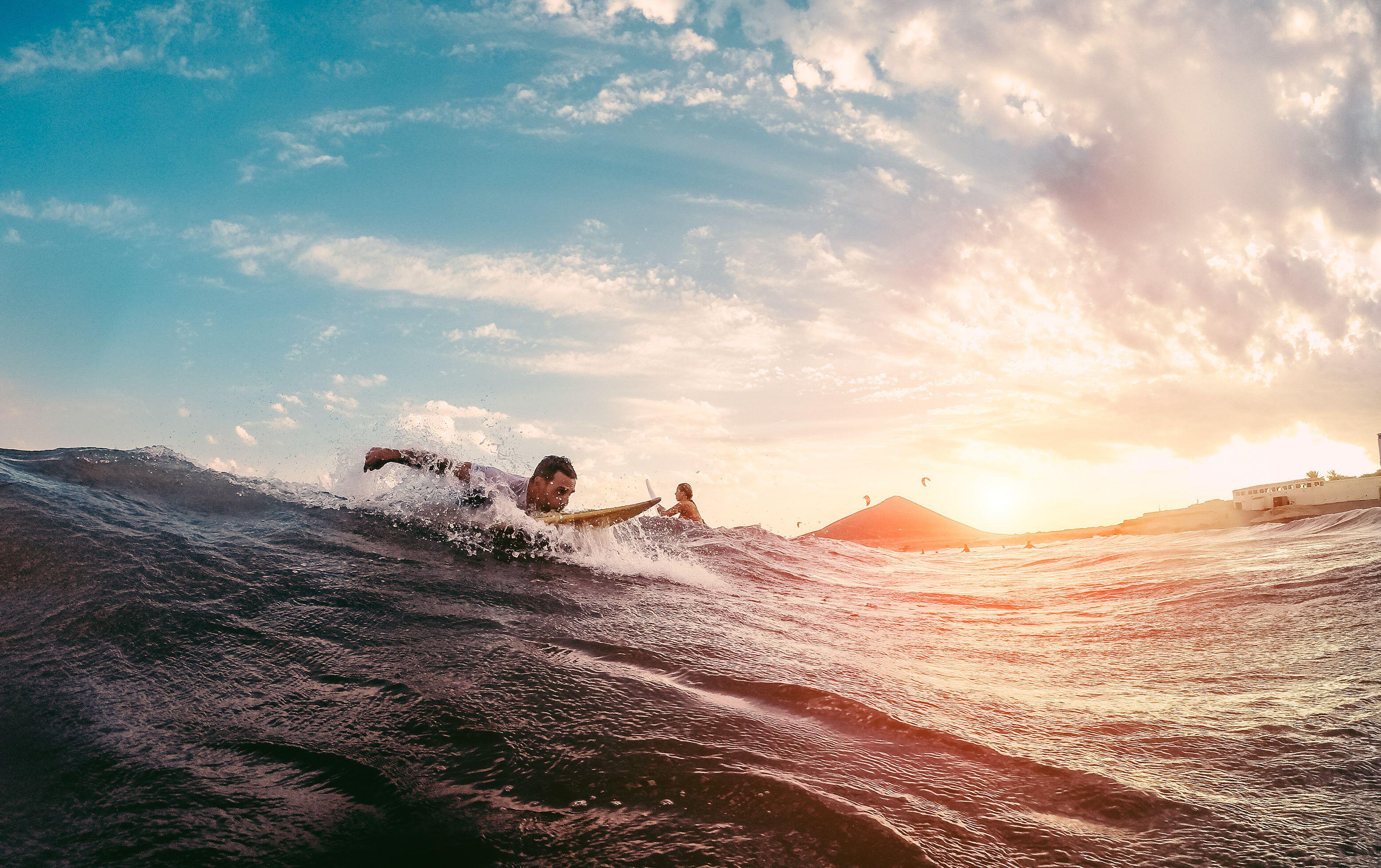 Surfer starting to ride a wave at sunset, Australia