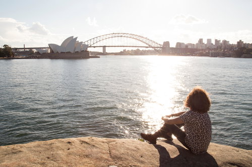 Young man relaxing by the ocean, at the Sydney Harbour, Australia