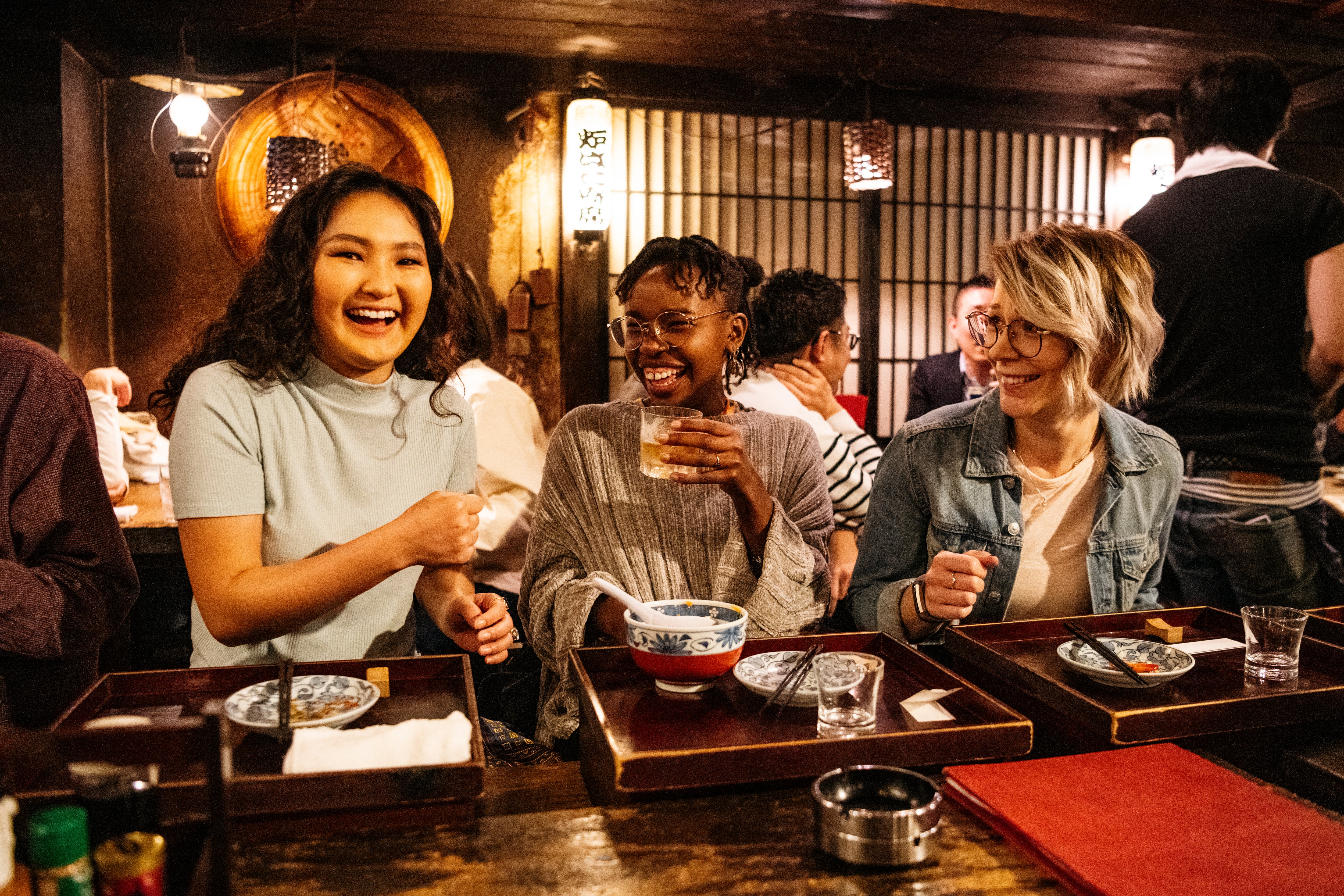Three female friends relaxing in Japanese Izakaya