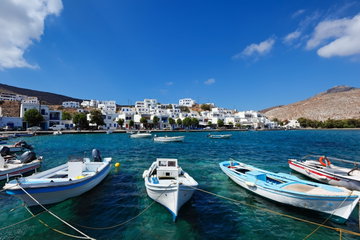 The small harbour in the fishing village Panormos in Tinos island, with small boats and traditional cycladic buildings