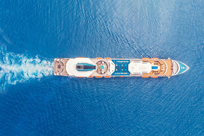 Cruise liner ship in ocean with blue water - Aerial top view