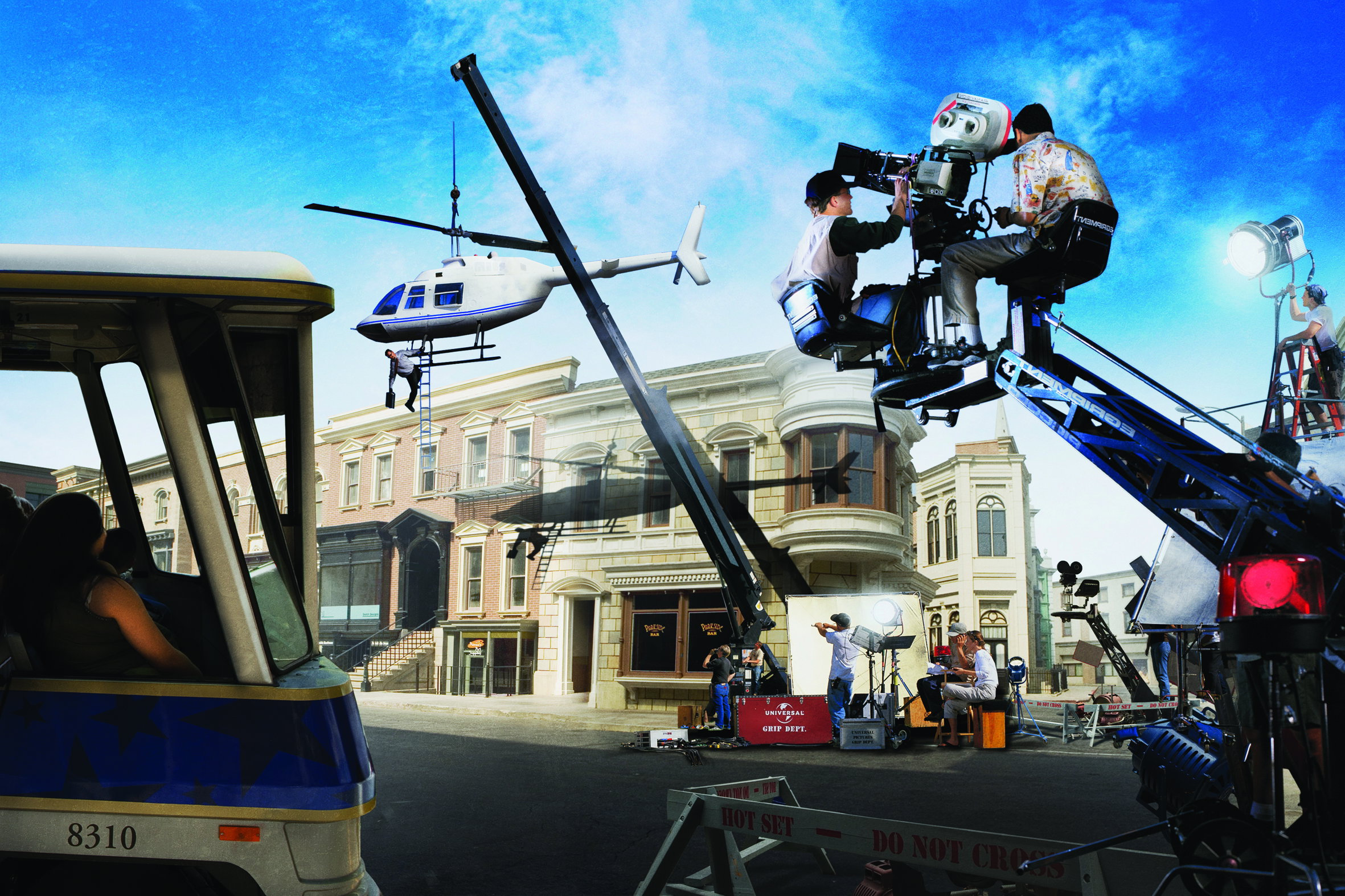 A stunt man hangs precariously from a helicopter on a crane as a cameraman films on a movie set  at Universal Studios Hollywood in California, USA