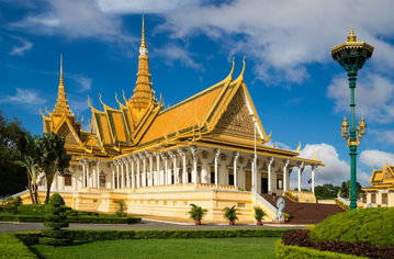 The Royal Palace in Phnom Penh with its stunning Khmer yellow and green tiled roof and beautiful manicured gardens, Cambodia