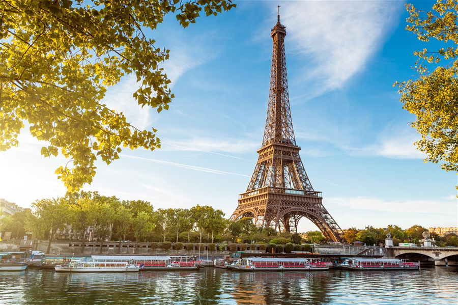 The Eiffel Tower in Paris, France, viewed from the River Seine on a bright sunny day